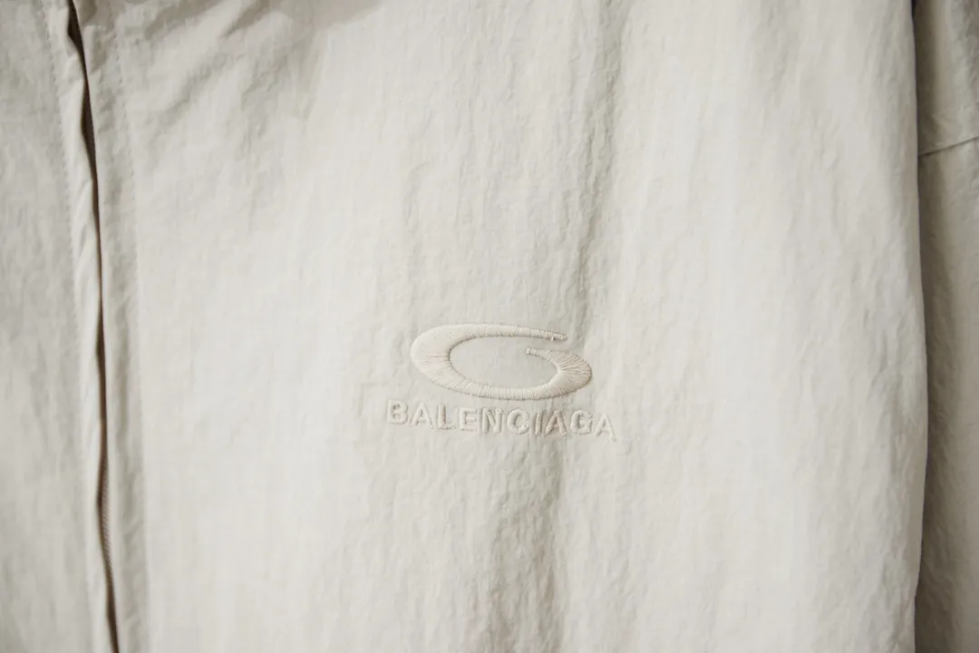 Balenciaga 𝘽𝘼𝙇𝙀𝙉𝘾𝙄𝘼𝙂𝘼 BLCG 26SS 71 front and rear half-circle letter embroidered sports suit Light luxury essential item for daily commuting for men and women Correct version Welcome to compare Detailed features · Customized matt Taslan jacket fabric · The fabric has undergone a waterproof coating process · The interior is made of three-grade polyester bird's eye mesh · OS ultra-loose silhouette design · Side zipper pockets Small stand-up collar design · Internal zipper pocket design · Elastic waistband design at the hem · Customized molded hardware zippers Jacket double puller design · Tajima high-speed embroidery machine with 100,000-needle three-dimensional design · Double side pockets on trousers · Original main mark washed tag brand packaging Color: Black/Milk Apricot Size: 46/48/50/52
